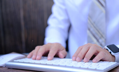Poster - At a wooden desk, a businessman types on a computer keyboard. Banking and strategy planning. In the office, a financial analyst is working. Accounting for businesses and project management