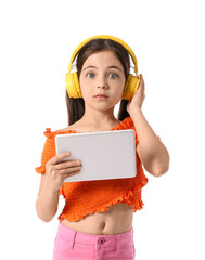 Wall Mural - Little girl with headphones and tablet computer on white background