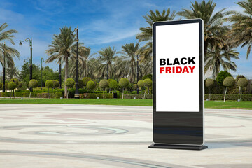 Fototapete -  Trade Show LCD Screen Stand Display Billboard with Black Friday Sale Sign in Empty City Street with Palm Trees. 3d Rendering
