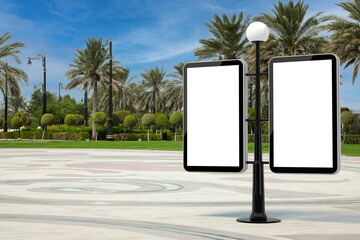 Poster - Street Lamp with Blank Banners as Template for Your Design in Empty City Street with Palm Trees. 3d Rendering