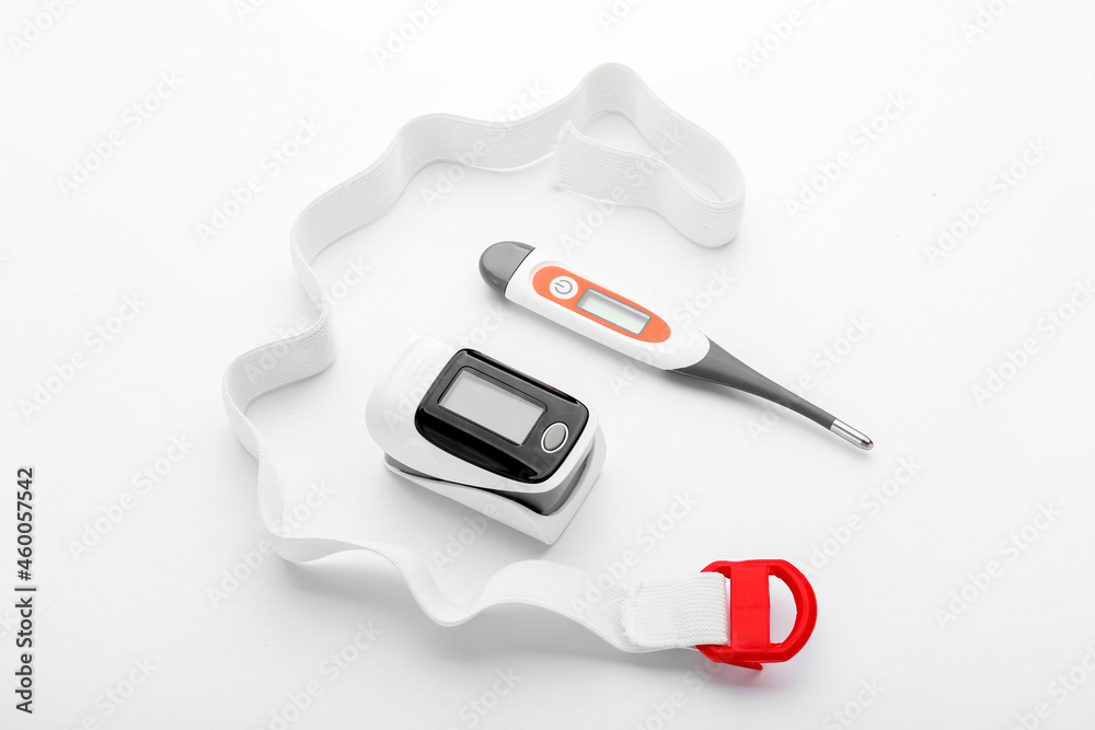 Pulse oximeter with thermometer and lace on white background