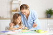 © Pixel-Shot - Little girl with her mother doing lessons at home