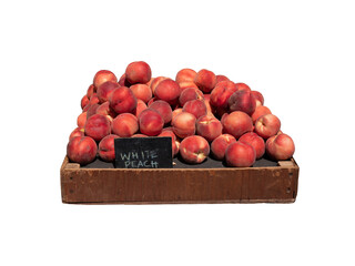 Fresh Organic peaches in wooden crate with black colour wooden price sign isolated on white