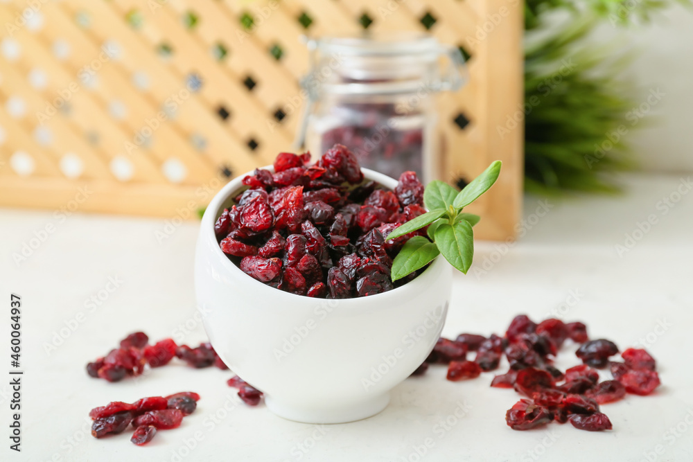 Bowl with tasty dried cranberries on table, closeup