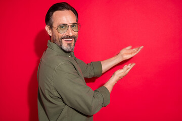 Sticker - Profile photo of nice optimistic age man point empty space wear khaki shirt eyewear isolated on red color background