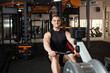 © Valeriia - handsome male coach sits on a simulator in gym. Imitation rowing, boat with oars, for rowers. Smiling, happy, sports active healthy lifestyle, indoor concept, coaching and individual lessons.