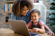 © ReeldealHD images - Mixed race girl using laptop for learning with mother