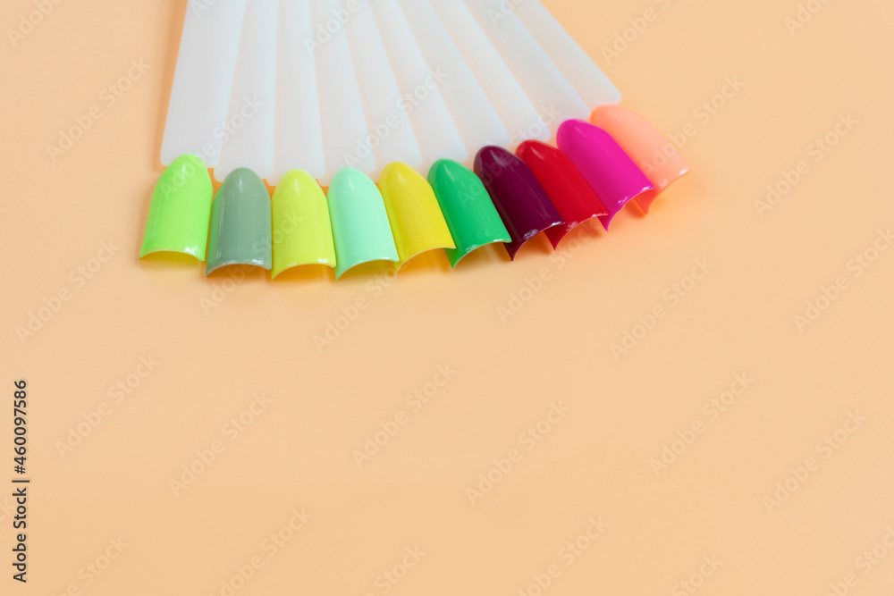 Multiсolor nail tips on a orange background. examples of manicure for ...