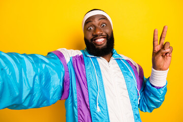 Canvas Print - Photo of attractive impressed dark skin man wear blue suit headband taking selfie showing v-sign smiling isolated yellow color background