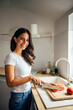 © bnenin - Adult woman, taking a picture in her kitchen.