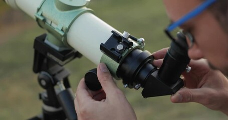 Wall Mural - man looking through a astronomical telescope outdoors.