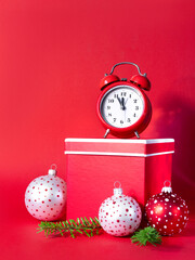 Wall Mural - Alarm clock with colorful Christmas balls,  tree branches and red gift boxes on  paper background. 5 minutes before the New Year. Creative greeting card.