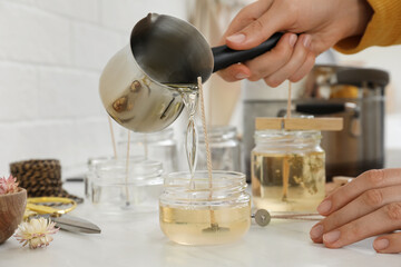 Wall Mural - Woman making candles at white table, closeup