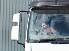UK, Truck Driver Looking At Side View Mirror