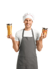 Canvas Print - Handsome chef holding jars with pasta on white background