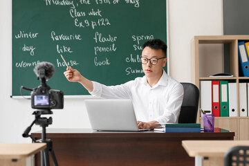 Canvas Print - Asian teacher conducting English lesson online