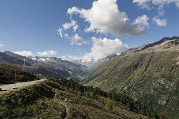 Canvas Print - Beautiful view of the mountain chains covered in grass and trees on a sunny day