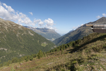 Poster - Beautiful view of the mountain chains covered in grass and trees on a sunny day