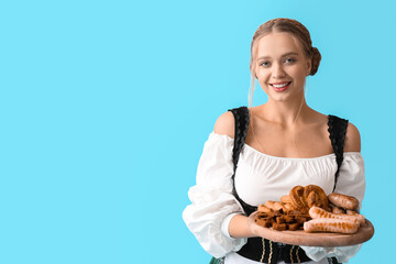 Poster - Beautiful woman in traditional German costume and with snacks on color background