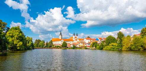 Wall Mural - Panorama view of Telc city, Czech Republic. Historical castle above the lake. UNESCO heritage. Summer day, blue sky with clouds.