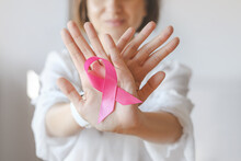 Unrecognized Female In White Blouse Showing Stop Sign With Hands And Pink Ribbon Attached. Breast Cancer Awareness Photo For Support And Health Care