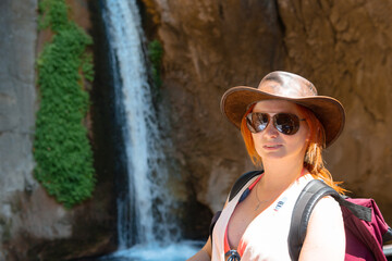 Sticker - Traveler girl with leather hat and backpack posing at the sapadere canyon and waterfall, Nature, Travel and vacation concept. Summer sunny day. Alanya turkey