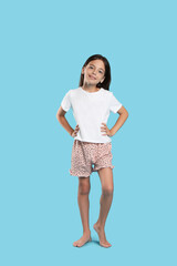 Wall Mural - Cute girl wearing pajamas on light blue background