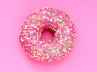 Donut with a pink icing on a pink background