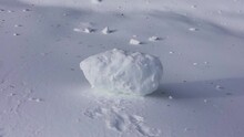 A Big Lump Of Snow Rolls Down The Snow-covered Mountainside And Does Not Break Because It Is Freezing. Super Slow Motion 1000 Fps.