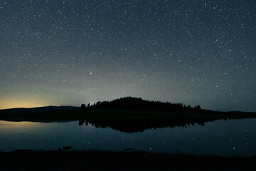 Poster - Beautiful starry night sky above a lake and landscape