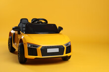 Child's Electric Toy Car On Yellow Background. Space For Text