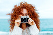 © ADDICTIVE STOCK - Red haired female taking picture on vintage photo camera