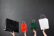 Crop of hand holding shopping bag or goodie bag for shopaholic or online shopping background