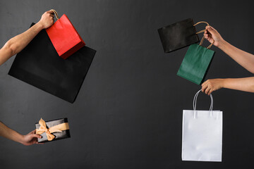 Poster - Crop of hand holding shopping bag or goodie bag for shopaholic or online shopping background
