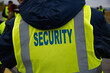 © arrideo - Back of male security guard wearing yellow reflector high-visibility vest
