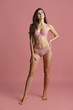 © master1305 - Portrait of young beautiful slim woman in lingerie posing isolated over pink studio background. Natural beauty concept.