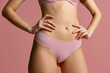 © master1305 - Beautiful body of young slim woman in lingerie, panties isolated on pink studio background. Natural beauty concept.