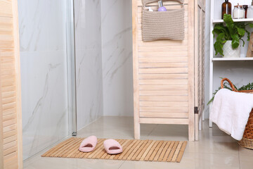 Canvas Print - Wooden mat with slippers on floor in bathroom