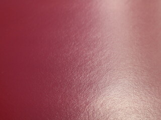 Wall Mural - burgundy glossy texture paper background in blurred focus with uneven lighting, dark warm blank canvas with light surface texture, dark red blank copy space, deep shade of red with cold pigment