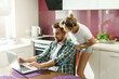 © blackday - Happy couple using laptop in the kitchen at morning