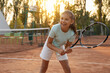 © New Africa - Cute little girl playing tennis on court outdoors