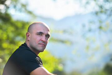 Close-up man outdoors on a background of mountains. Portrait.