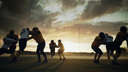 Wall Mural - American Football Field Start of Offensive Play with a Snap Pass: Successful Player Jumping Over Defense Running to Score Touchdown Points. Professional Athletes Compete Fight for Victory