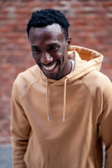 A young man smiling happily on the street