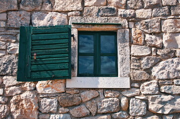 Wooden rustic window on stone wall