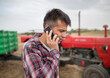 © Budimir Jevtic - Male agronomist standing in harvested field talking on phone