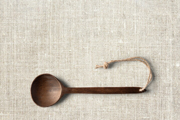 Wooden cooking  spoon horizontally lying on clean wooden table top view shot, with space for text.