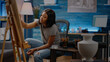 © DC Studio - African american artist working on fine art creation while sitting in workshop room at home. Black young woman with artistic imagination drawing white vase on canvas for masterpiece