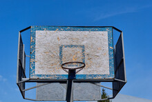Old And Vintage Basketball Backboard And Hoop. Basketball Hoop On A Background Of Blue Sky And White Clouds. 