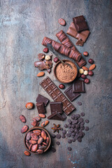 Wall Mural - Chocolate background with lots of bars, nuts, drops and cocoa beans